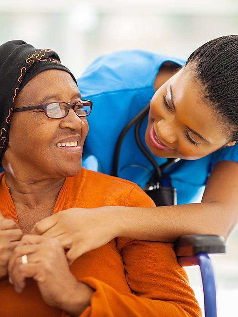 A caregiver and a client talking together in a bright living room