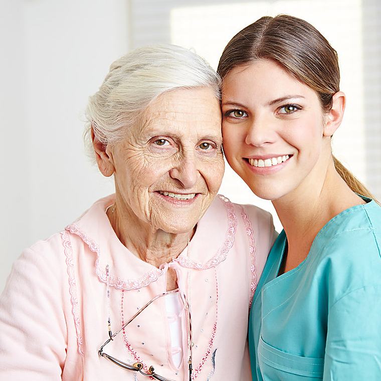 A caregiver holding a client's hand warmly
