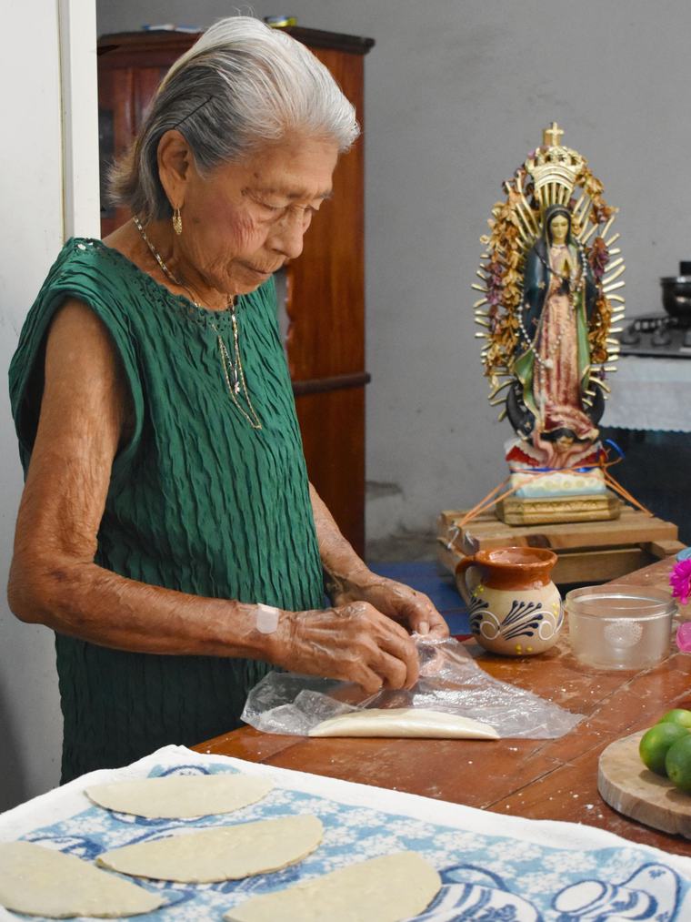 A caregiver helping prepare a meal in a home kitchen